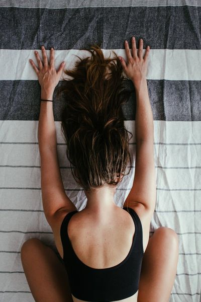 Person doing a deep stretching exercise on a yoga mat.